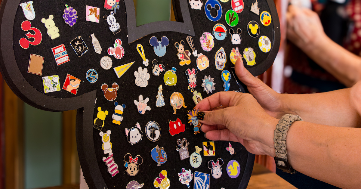 Guide to Disney Pin Trading, guests trading pins on a Mickey-shaped pin board