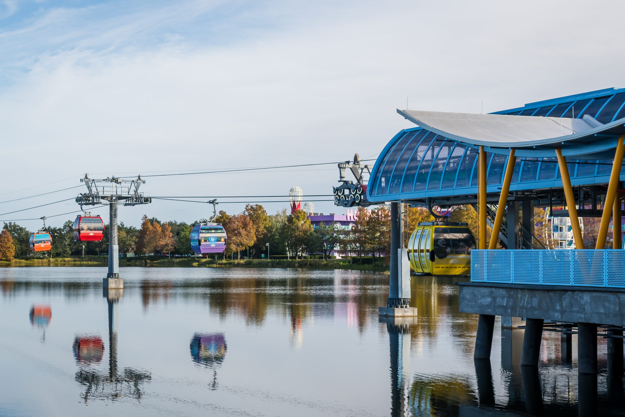 The Disney Skyliner takes off over the water from Disney's Pop Century Resort station